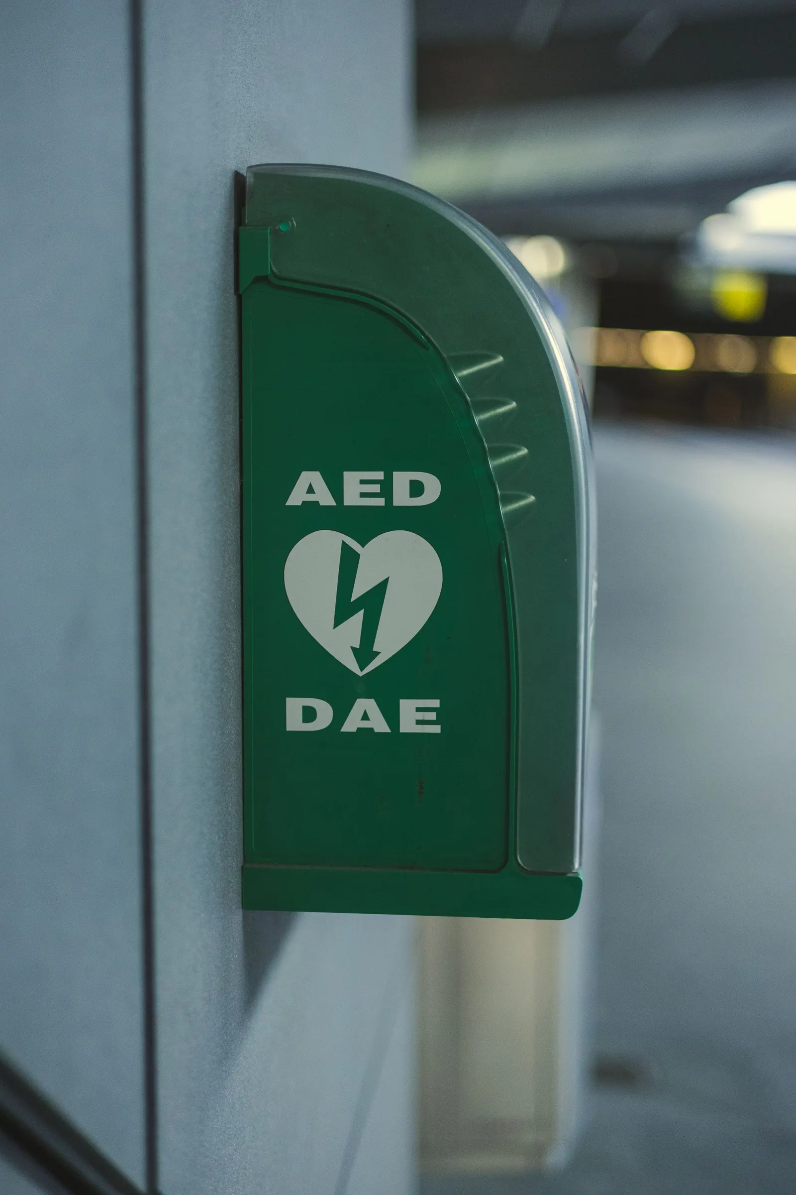 Een groene AED-kast aan de muur