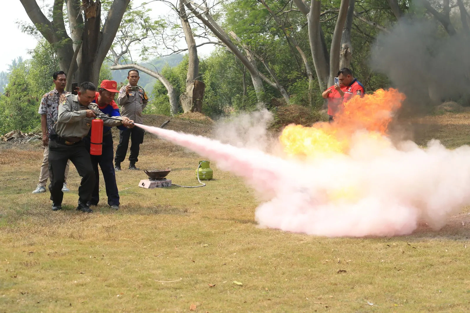 Cursisten blussen een oefenbrand met een brandblusser