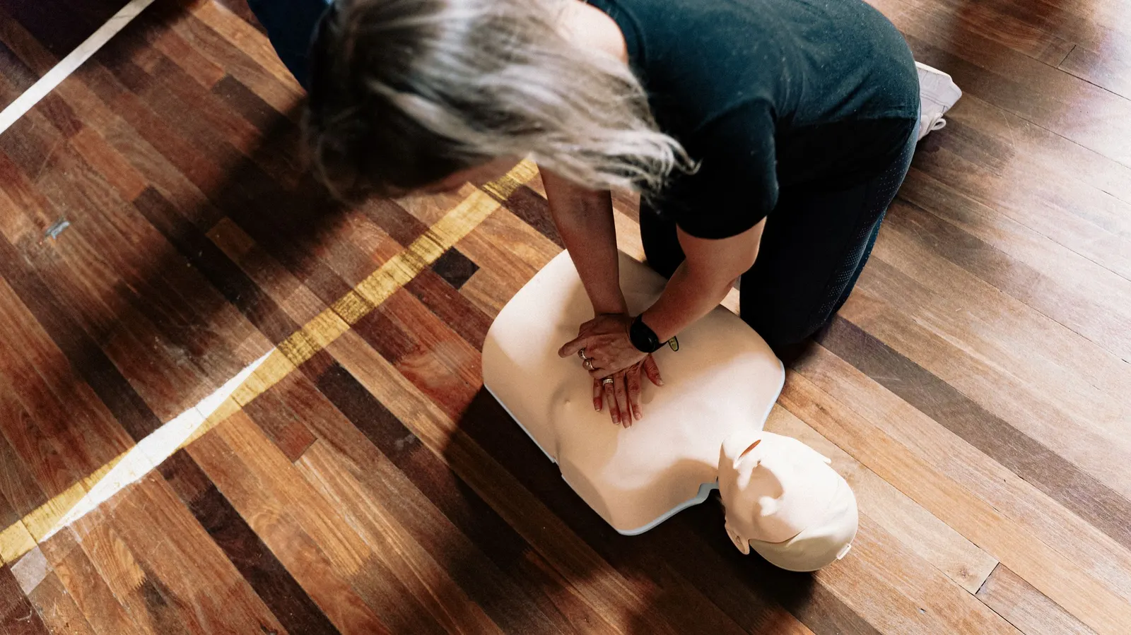 Een cursist oefent borstcompressies op een oefenpop