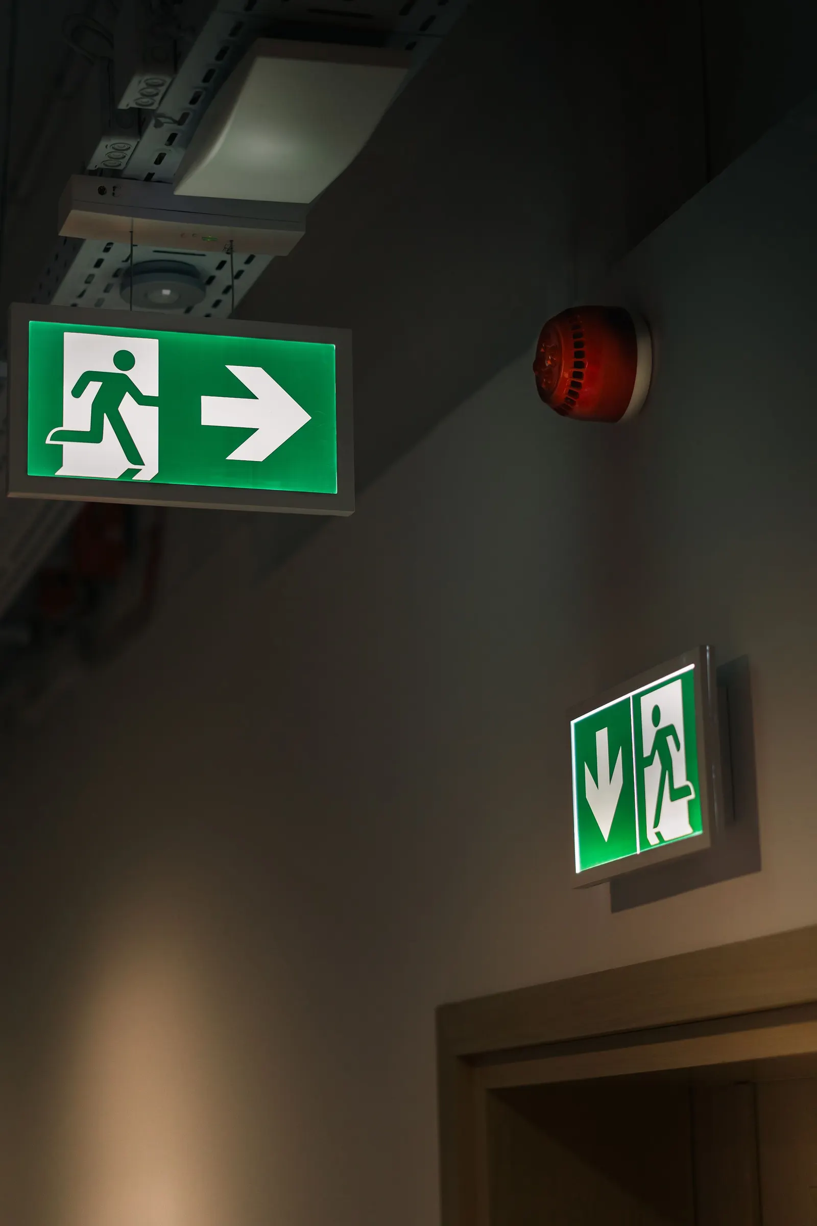 Groene nooduitgangsborden in een gang van een bedrijfspand